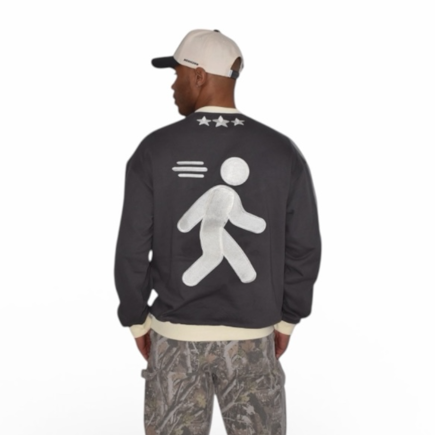 Person wearing a charcoal gray crewneck with a white graphic on the back, standing against a white background